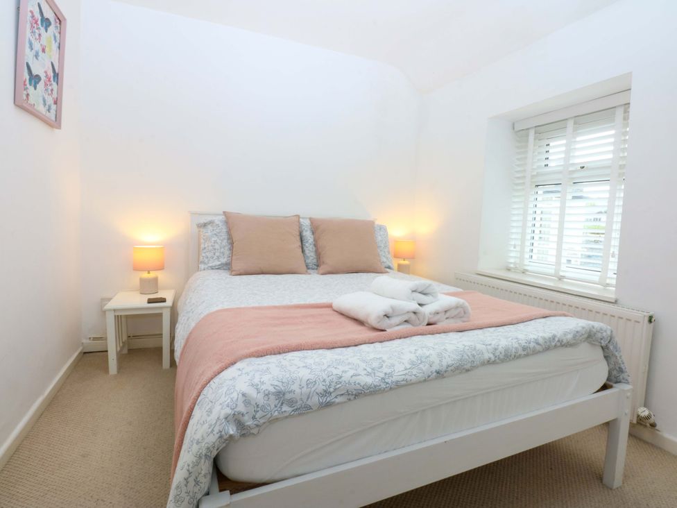 A bedroom with a bed and bedside table at 27 Kingshead Street Pwllheli