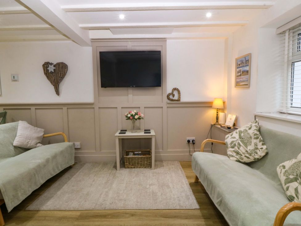 A living room with a television and a coffee table at 27 Kingshead Street Pwllheli