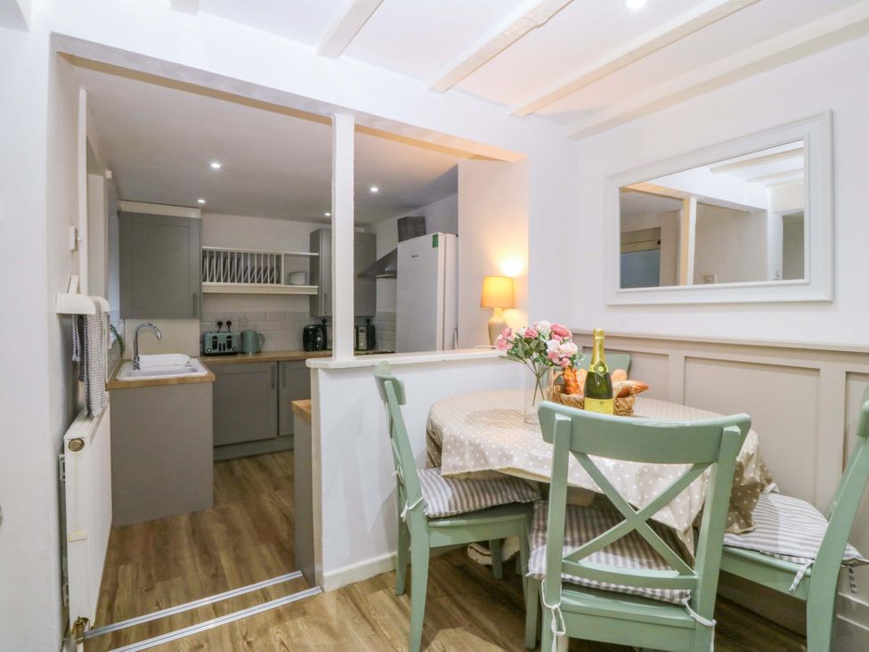 A dining room with a table and chairs at 27 Kingshead Street Pwllheli