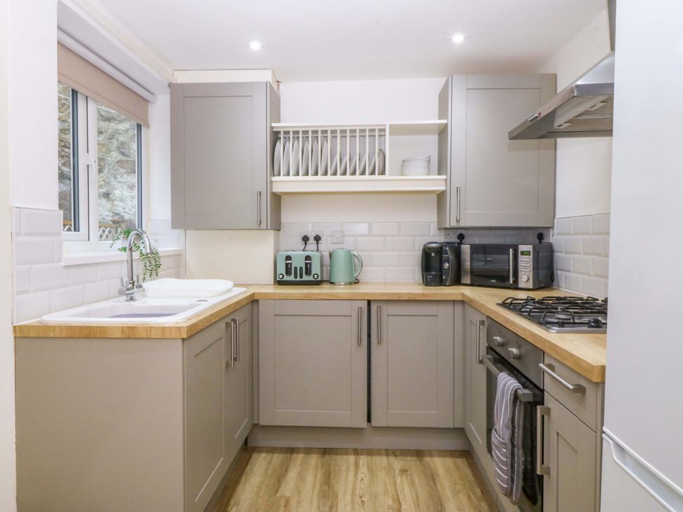 A kitchen with cabinets and appliances at 27 Kingshead Street Pwllheli