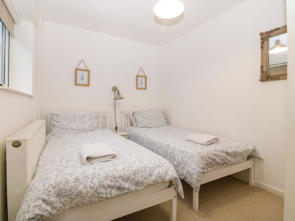 A bedroom with two beds and a radiator at 27 Kingshead Street in Pwllheli