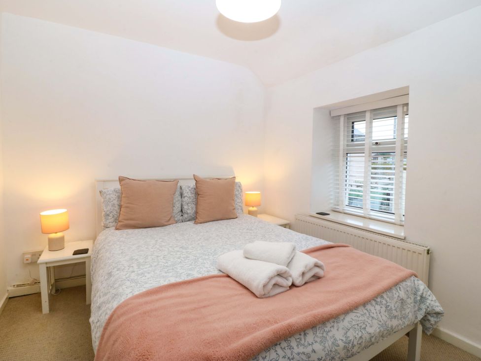 A bedroom with a bed and bedside tables at 27 Kingshead Street Pwllheli