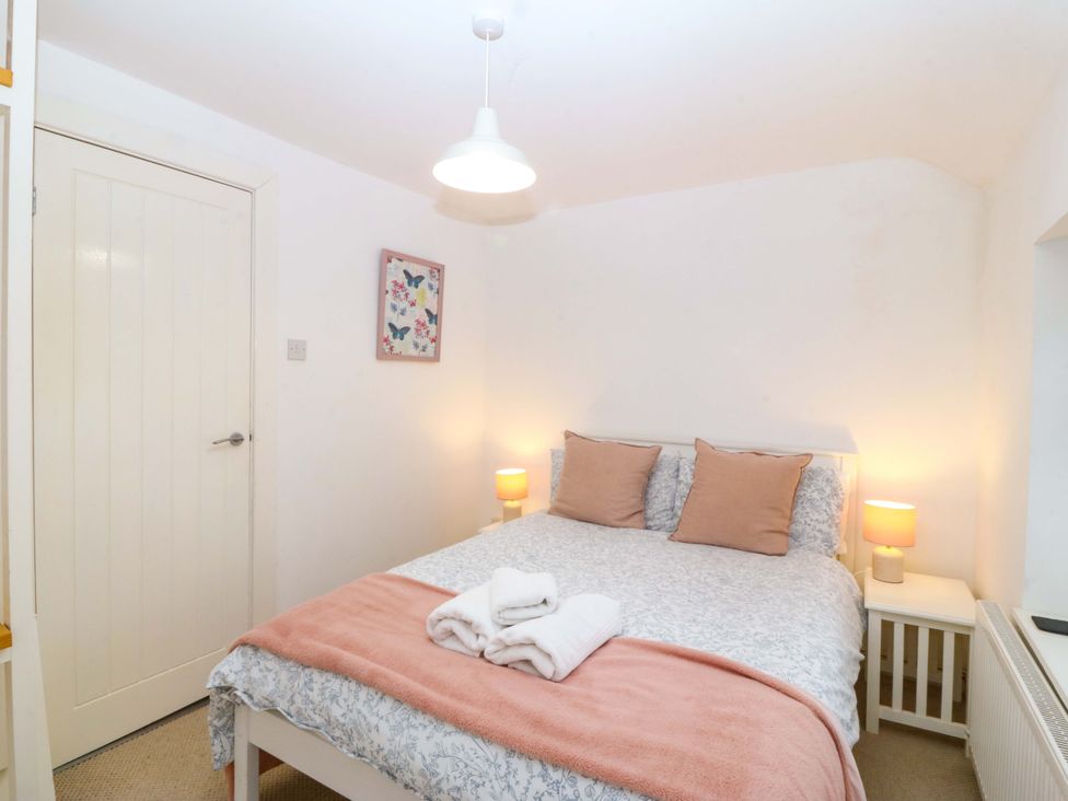 A bedroom with a bed and bedside tables at 27 Kingshead Street in Pwllheli