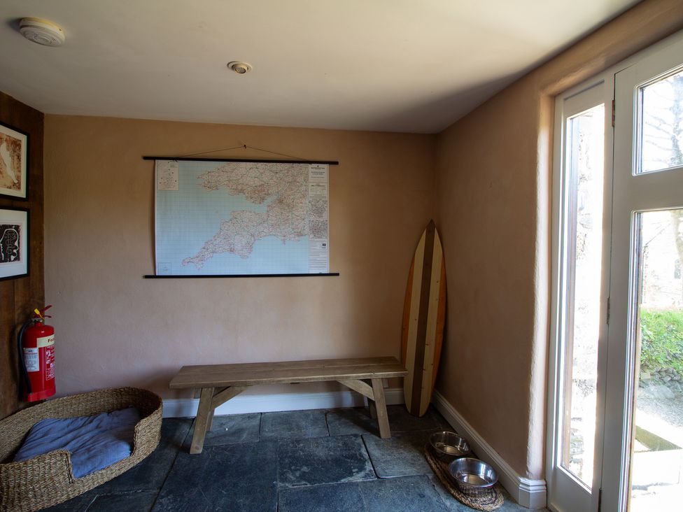 An entryway with a map and bench at Carrows Stable in Morwenstow