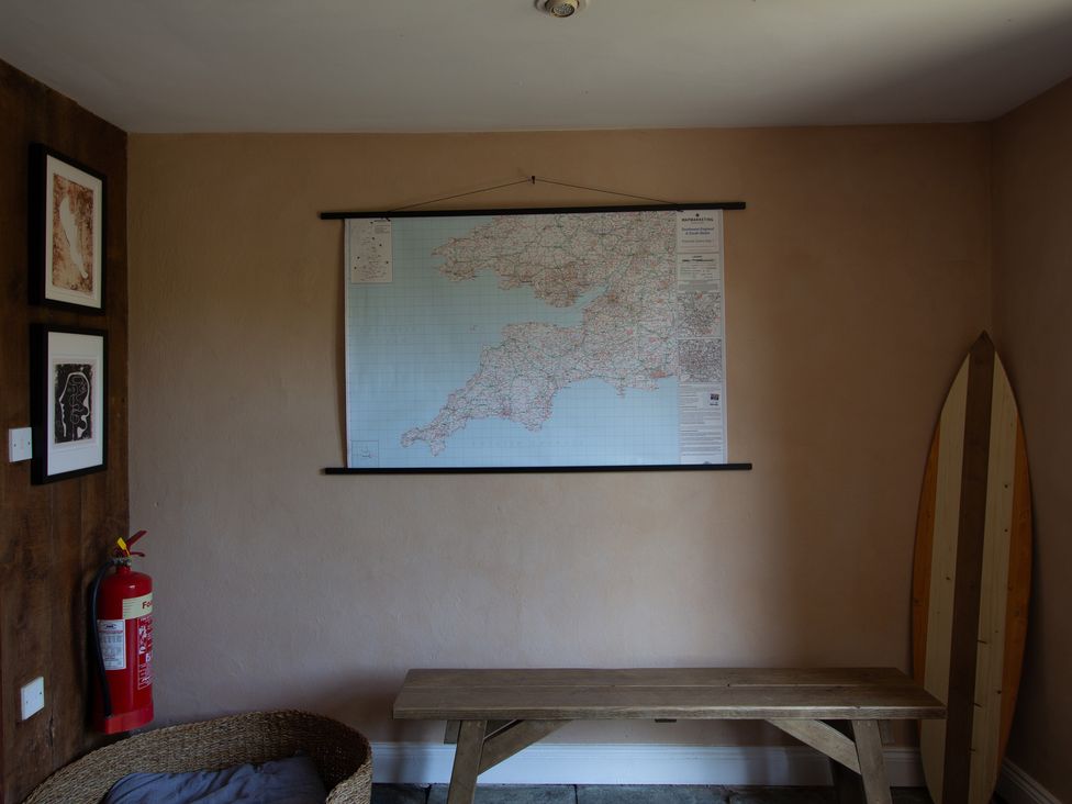 A room with a map on the wall a fire extinguisher and a wooden bench at Carrows Stable Morwenstow