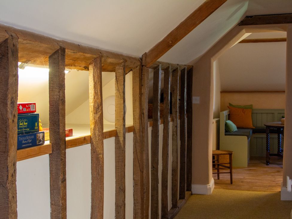 A hallway with wooden beams and a sofa at Carrows Stable Morwenstow