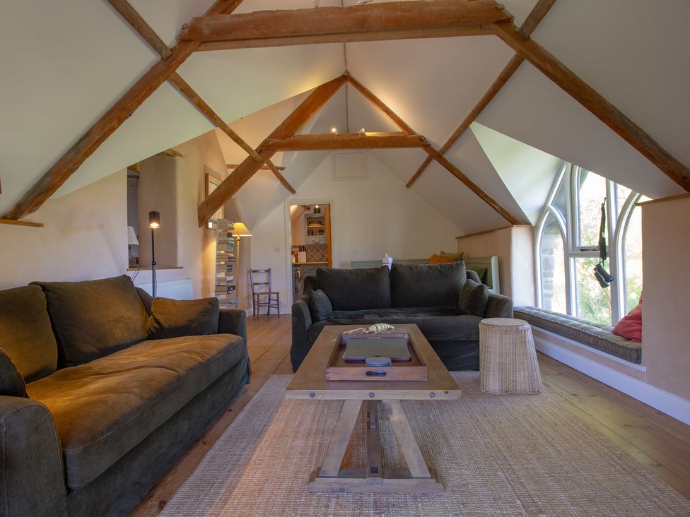A living room with sofas and a coffee table at Carrows Stable in Morwenstow