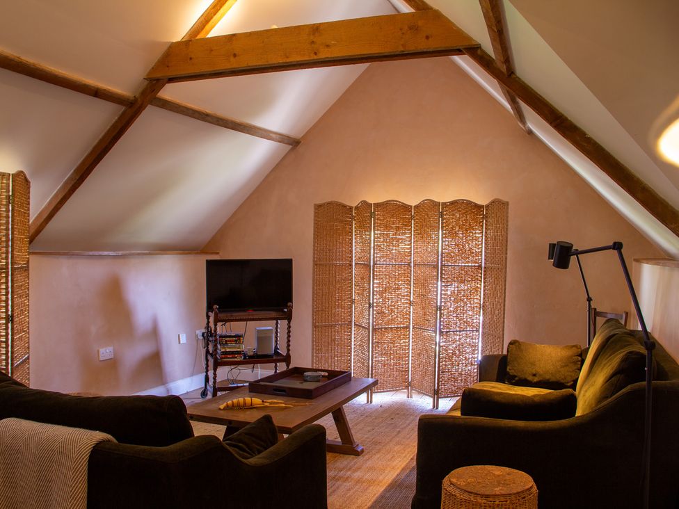 A living room with a television and sofa at Carrows Stable in Morwenstow