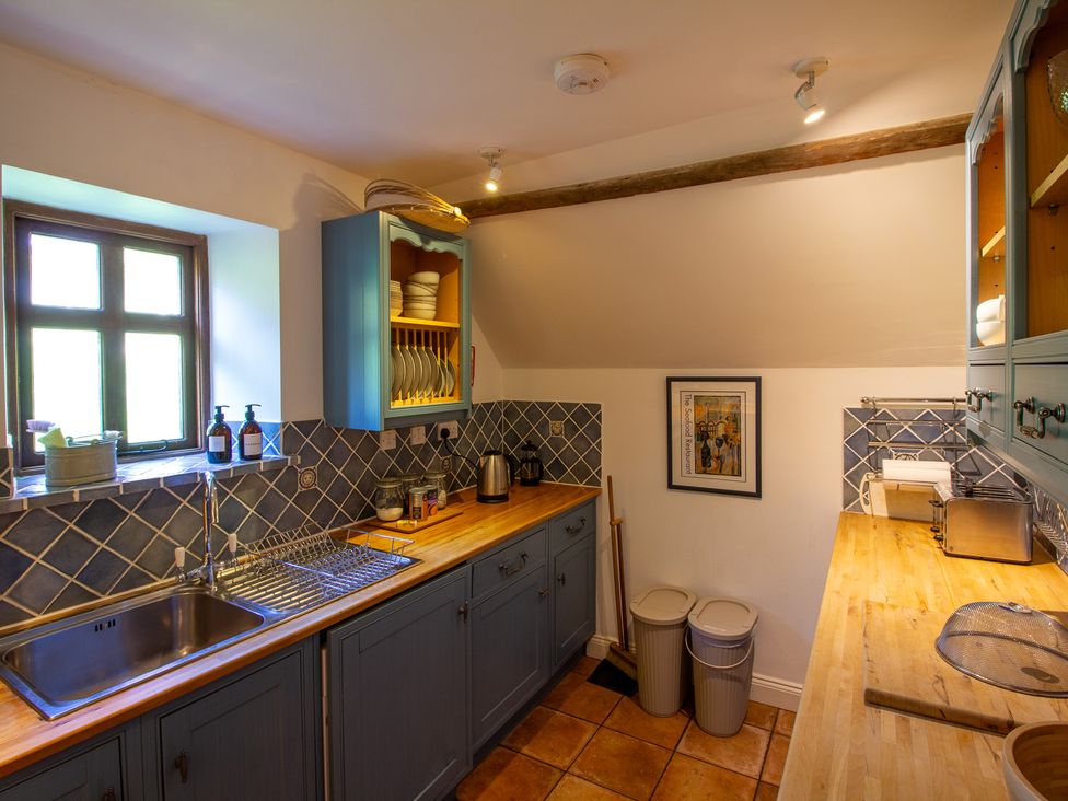 A kitchen with cabinets and sink at Carrows Stable in Morwenstow