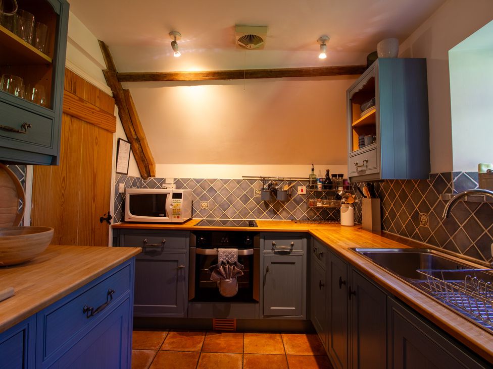 A kitchen with a microwave and oven at Carrows Stable in Morwenstow