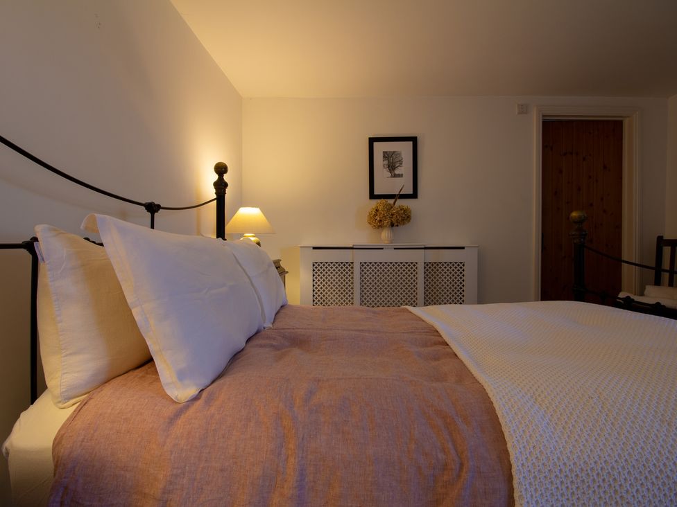 A bedroom with a bed and a cabinet at Carrows Stable Morwenstow