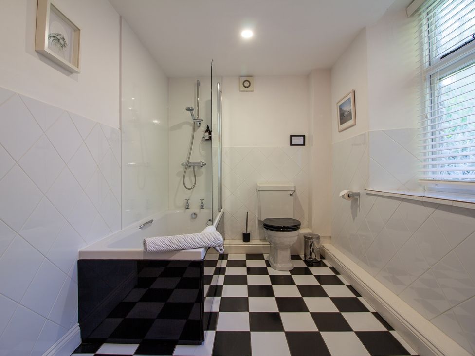 A bathroom with a bathtub, toilet, shower, and sink at Carrows Stable in Morwenstow
