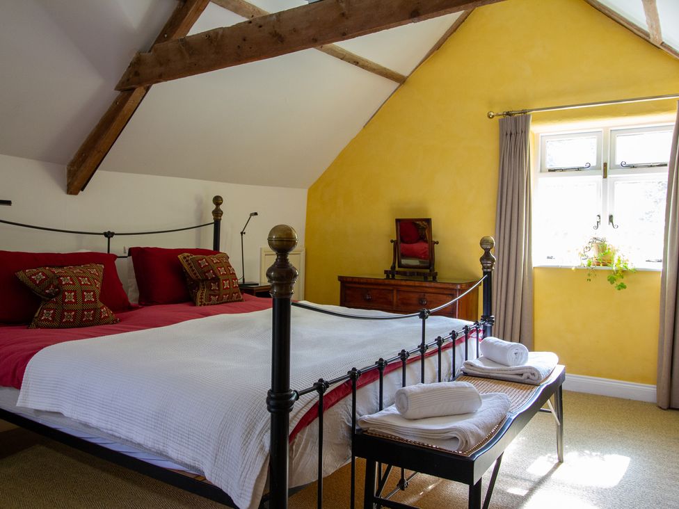 A bedroom with a bed and dresser at Carrows Stable in Morwenstow
