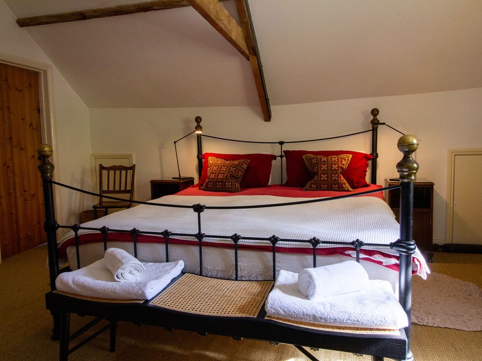 A bedroom with a bed and towels at Carrows Stable in Morwenstow