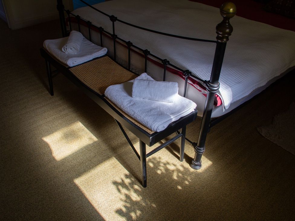 A bedroom with towels on a bench at Carrows Stable Morwenstow