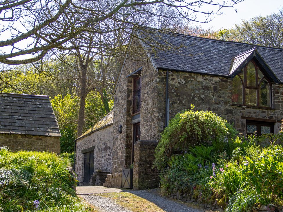 A stone house with a slate roof and garden at Carrows Stable in Morwenstow