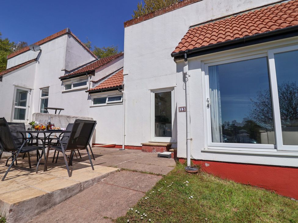 An outdoor seating area with a table and chairs at 13 Manorcombe Bungalows Honicombe Holiday Village near Gunnislake