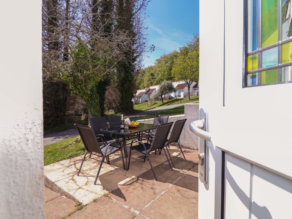 An outdoor patio area with a table and chairs at 13 Manorcombe Bungalows near Gunnislake