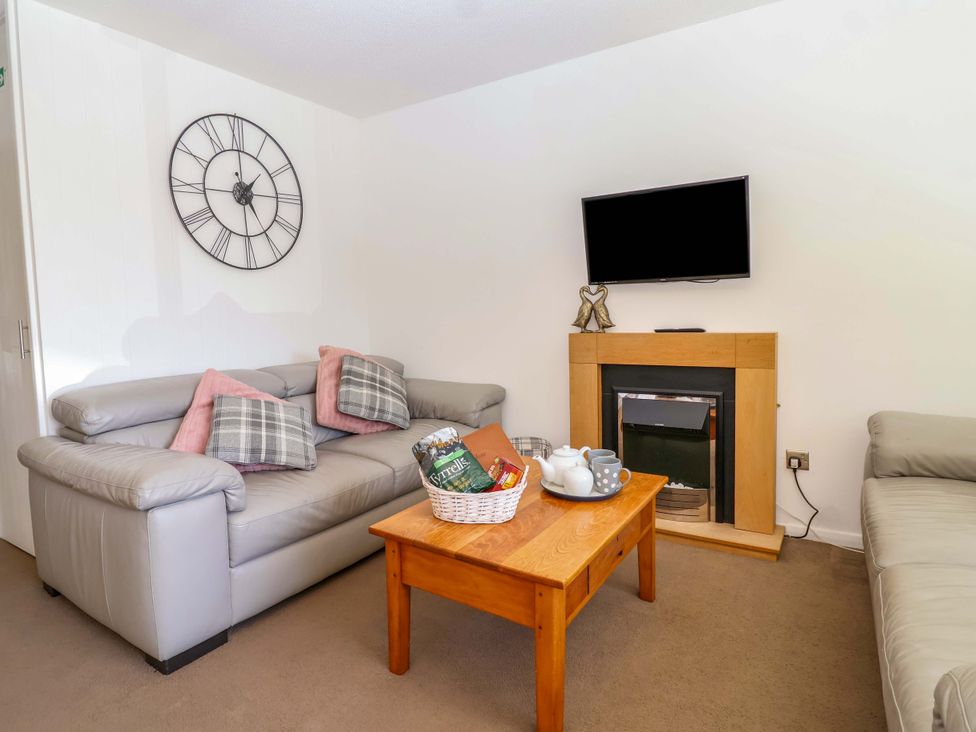 A living room with a sofa and coffee table at 13 Manorcombe Bungalows near Honicombe Holiday Village