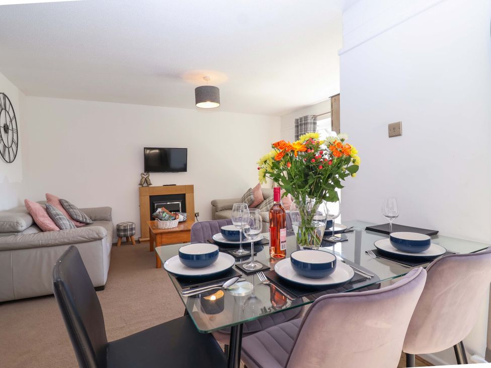A living room with sofa and dining area at 13 Manorcombe Bungalows Honicombe Holiday Village near Gunnislake