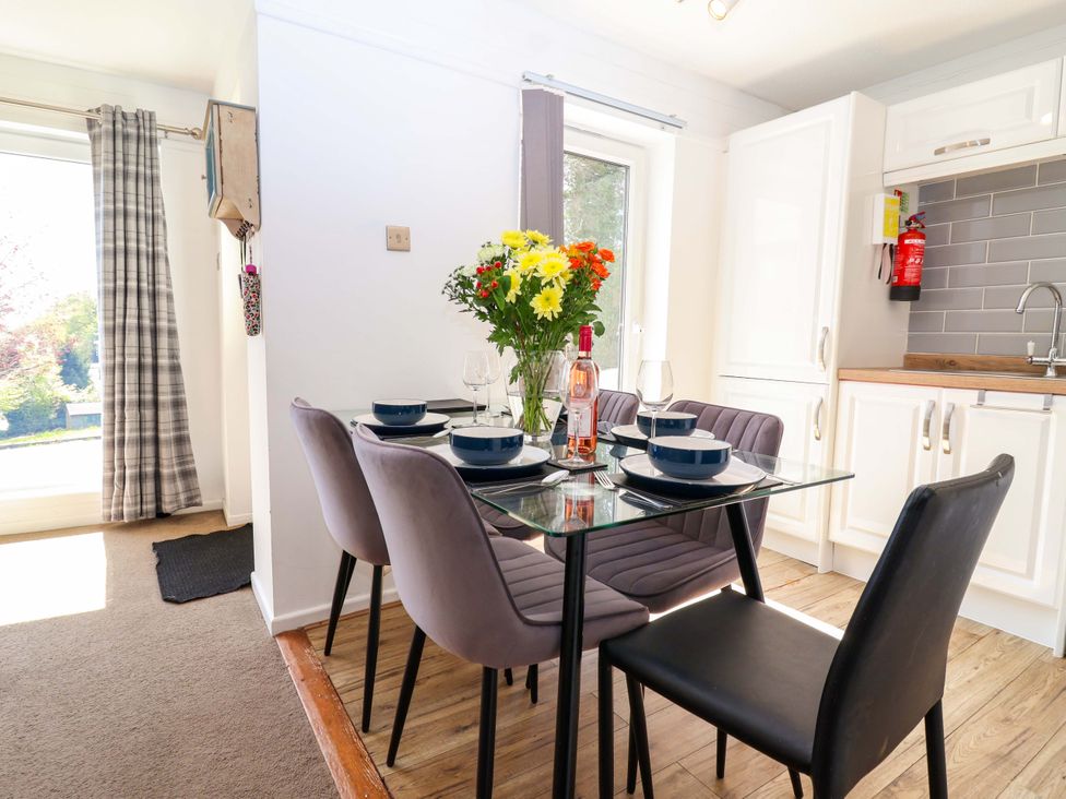 A dining room with a table set for meals at 13 Manorcombe Bungalows Honicombe Holiday Village near Gunnislake