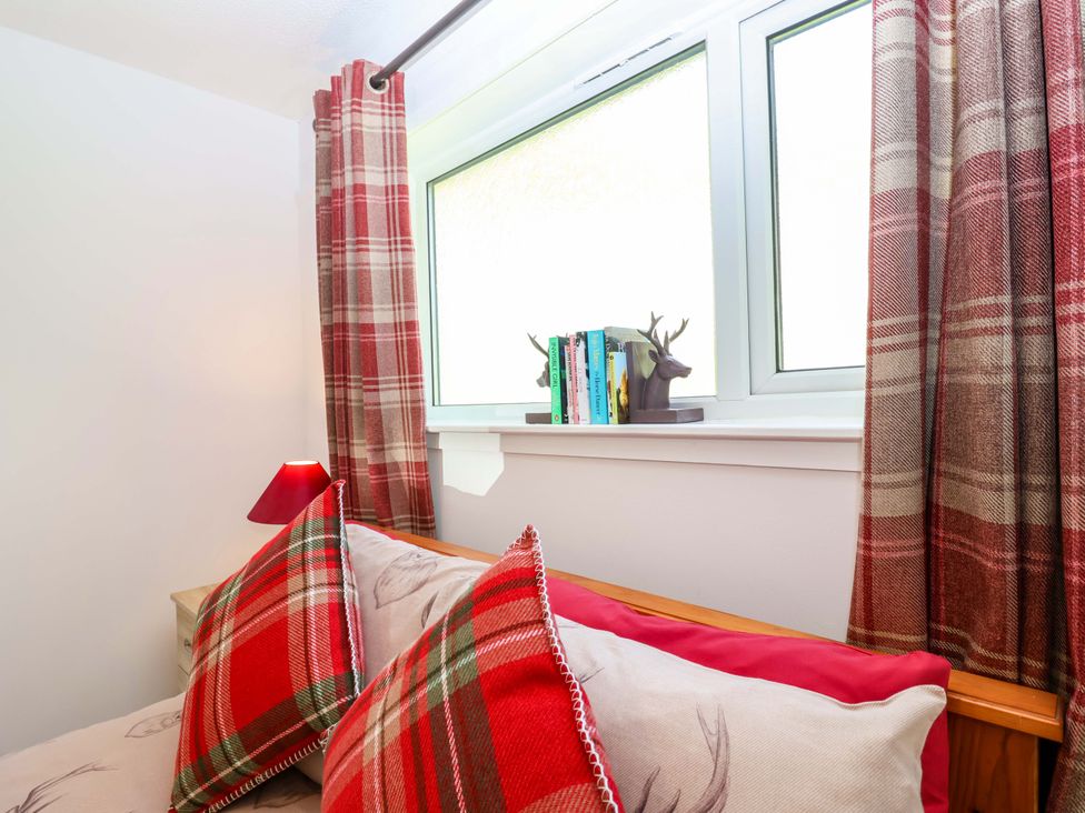 A bedroom with a bed and window at 13 Manorcombe Bungalows Honicombe Holiday Village near Gunnislake