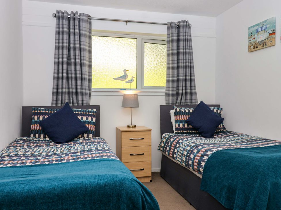 A bedroom with two beds and a lamp at 13 Manorcombe Bungalows Honicombe Holiday Village near Gunnislake