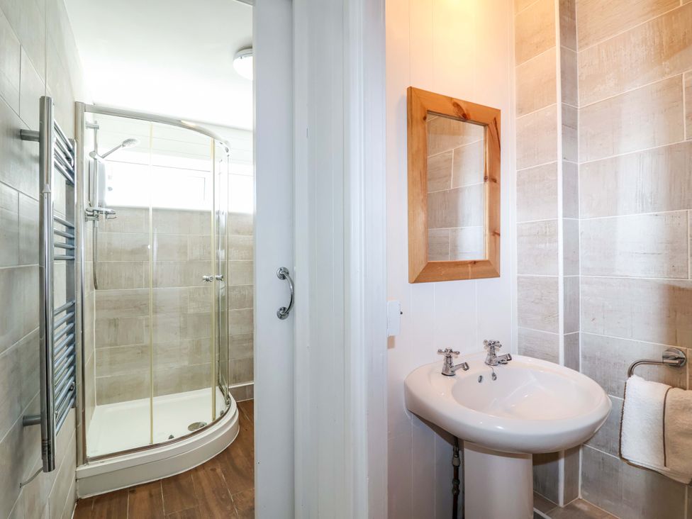 A bathroom with a shower and wash basin at 13 Manorcombe Bungalows Honicombe Holiday Village near Gunnislake