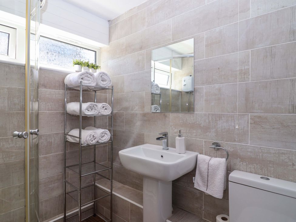 A bathroom with shower, sink, and towel rack at 13 Manorcombe Bungalows near Gunnislake