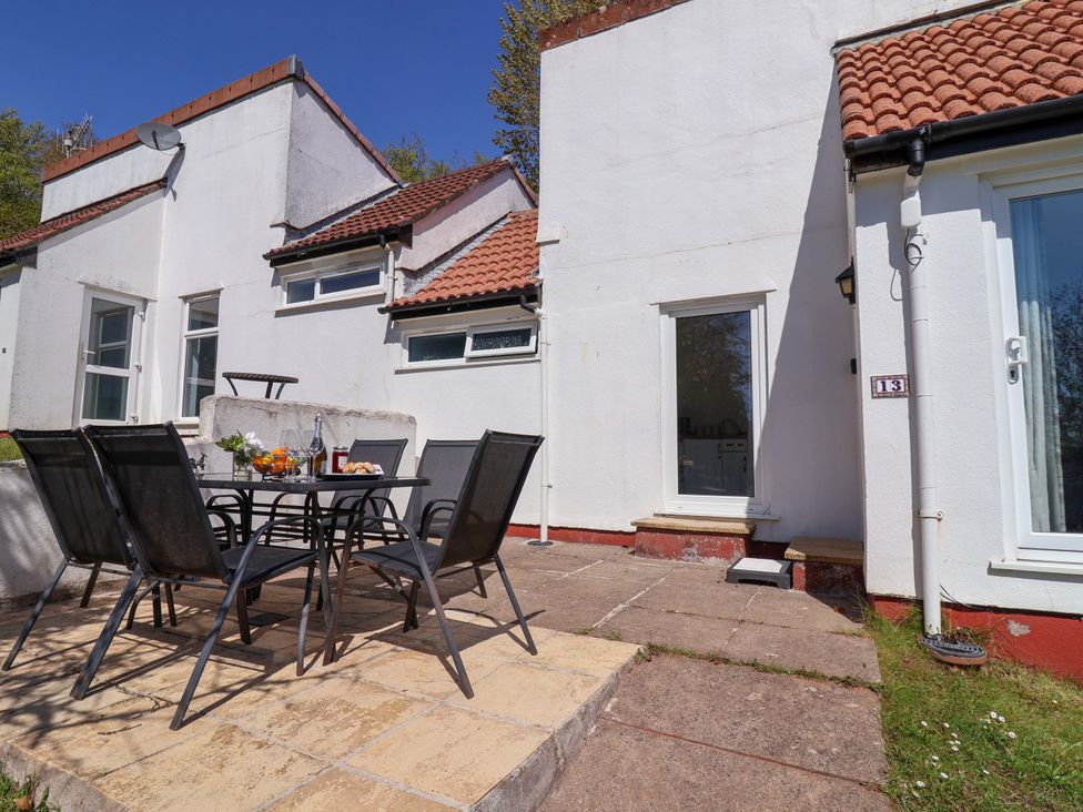 An outdoor patio with a table and chairs at 13 Manorcombe Bungalows Honicombe Holiday Village near Gunnislake