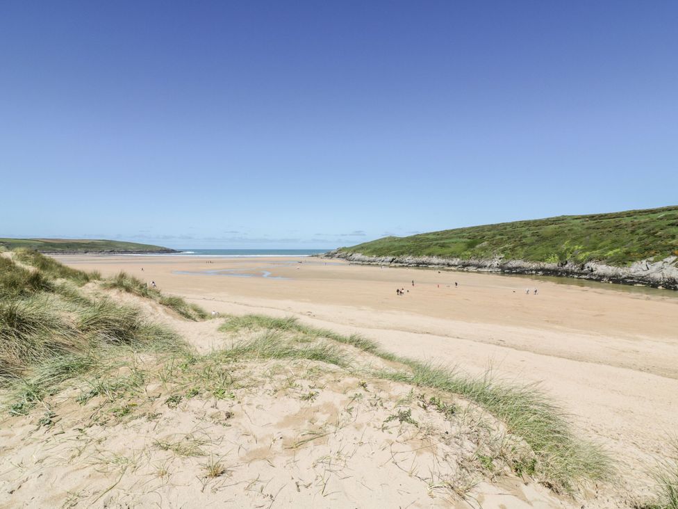 A beach scene with sand and water at No 1 The Hinges Crantock