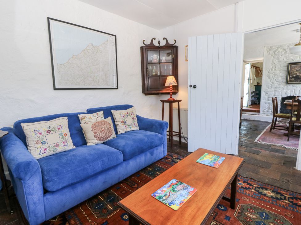 A living room with a blue sofa and coffee table at Dolwylan Cottage in Cwmtydu near New Quay