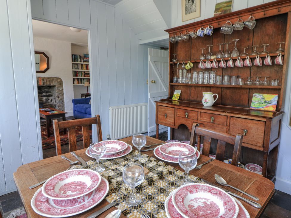 A dining room with a table set for dinner at Dolwylan Cottage in Cwmtydu near New Quay