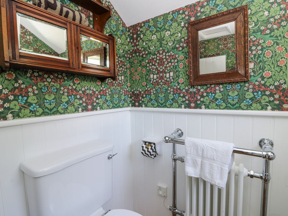 A bathroom with a toilet and a towel rack at Dolwylan Cottage in Cwmtydu near New Quay