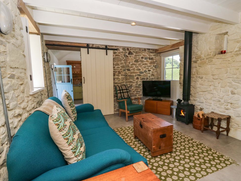 A living room with a sofa and coffee table at Dolwylan Barn in Cwmtydu near New Quay
