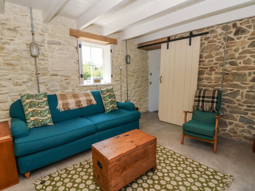 A living room with a sofa and coffee table at Dolwylan Barn in Cwmtydu near New Quay
