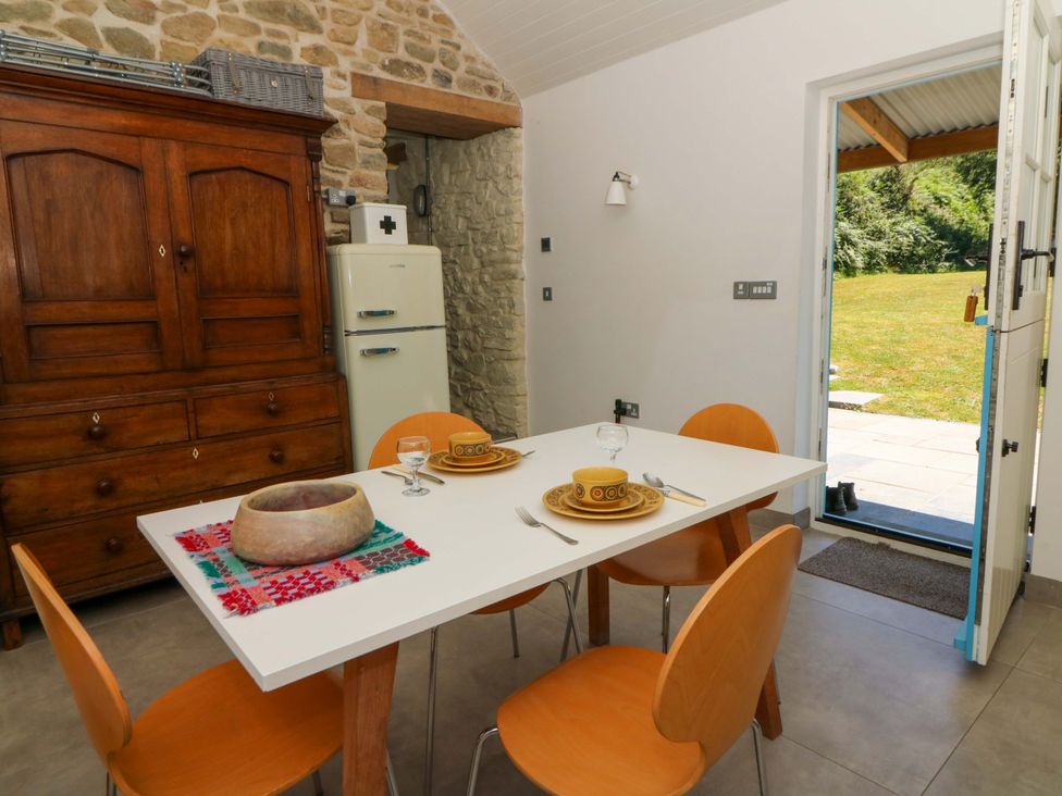 A dining room with a table set for meals at Dolwylan Barn Cwmtydu near New Quay
