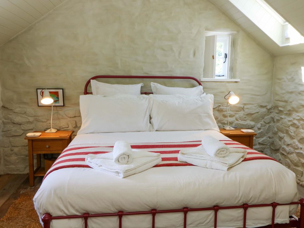 A bedroom with a bed and bedside tables at Dolwylan Barn in Cwmtydu near New Quay