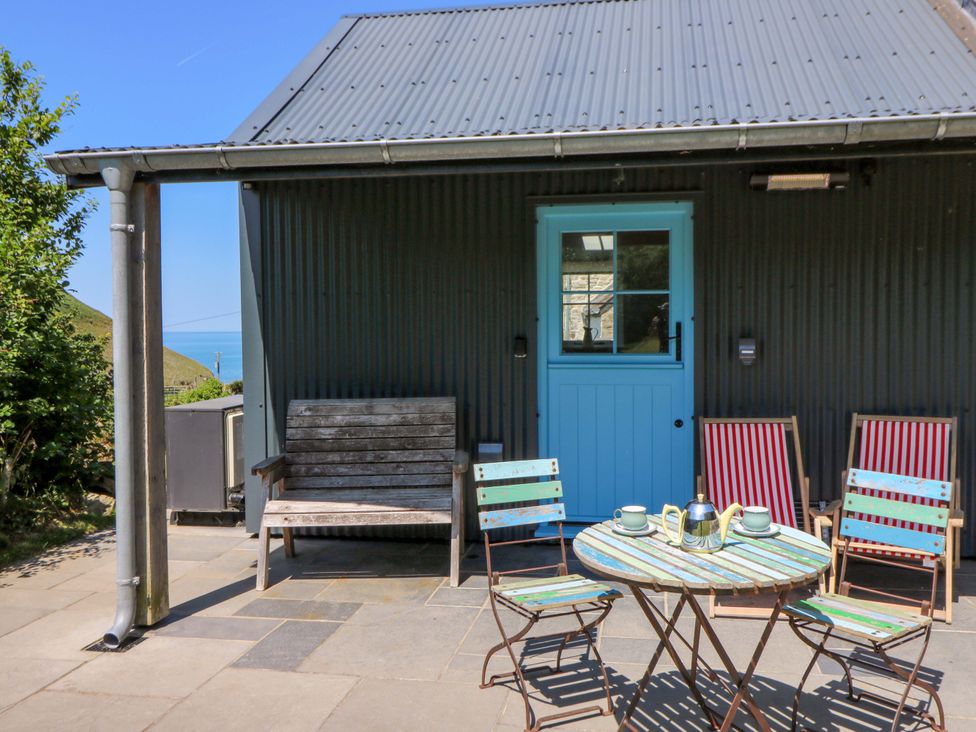Outdoor seating area with chairs and table at Dolwylan Barn Cwmtydu near New Quay