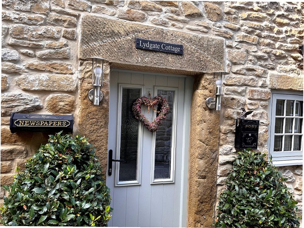 An entrance with a door and decorations at Lydgate Cottage in Eyam