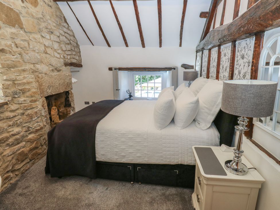 A bedroom with a bed and two lamps at Lydgate Cottage in Eyam