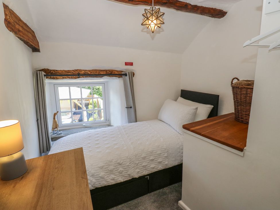 A bedroom with a bed and lamp at Lydgate Cottage in Eyam