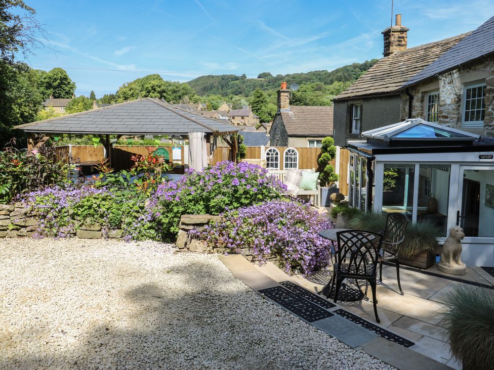 A garden with a gazebo and flowers at Lydgate Cottage in Eyam
