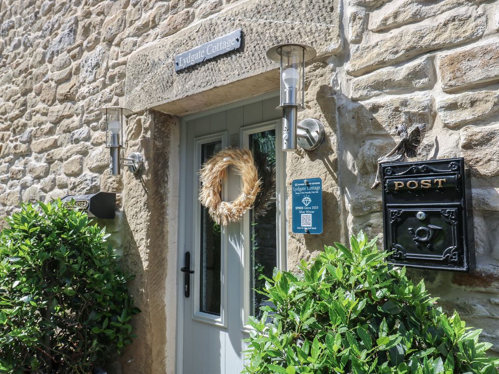 An entrance with a door and wreath at Lydgate Cottage in Eyam