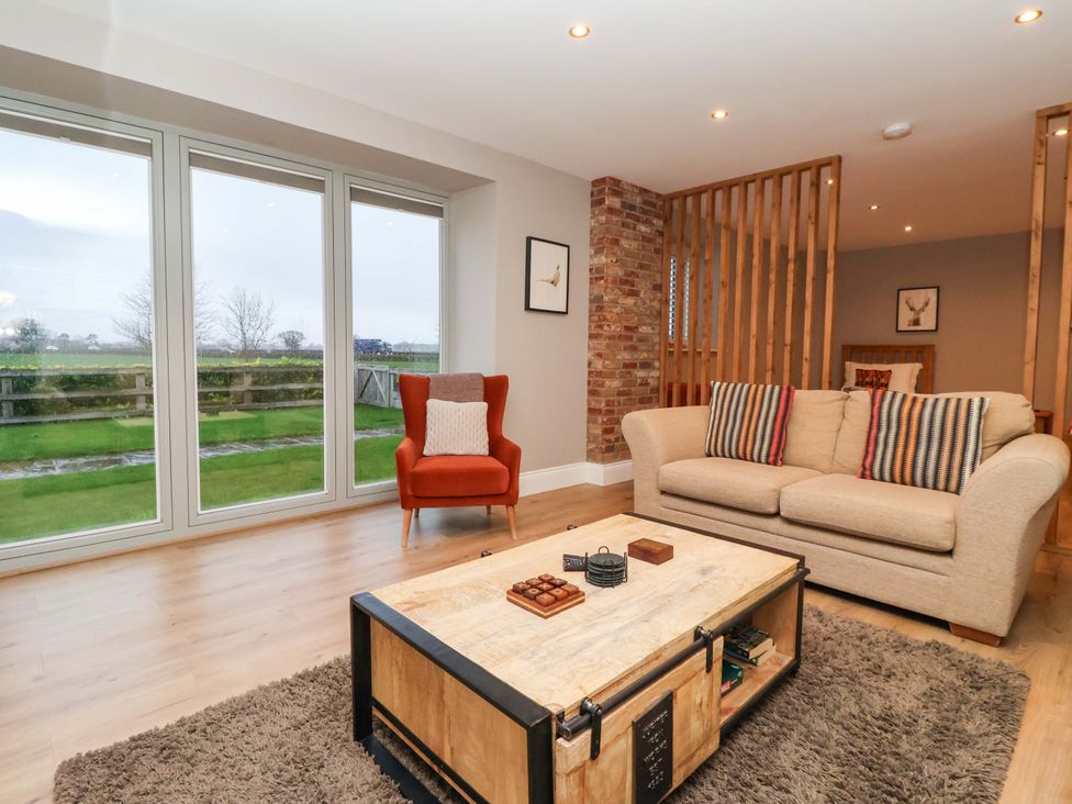 A living room with a sofa and an armchair at The Cart House in Wilberfoss
