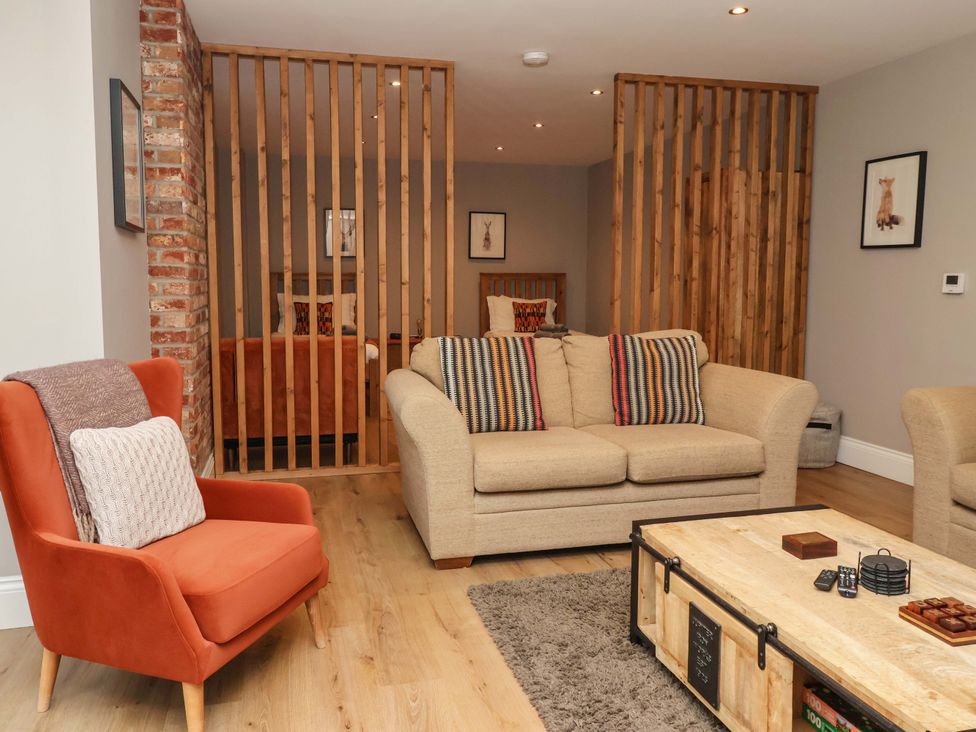 A living room with a sofa and armchair at The Cart House in Wilberfoss