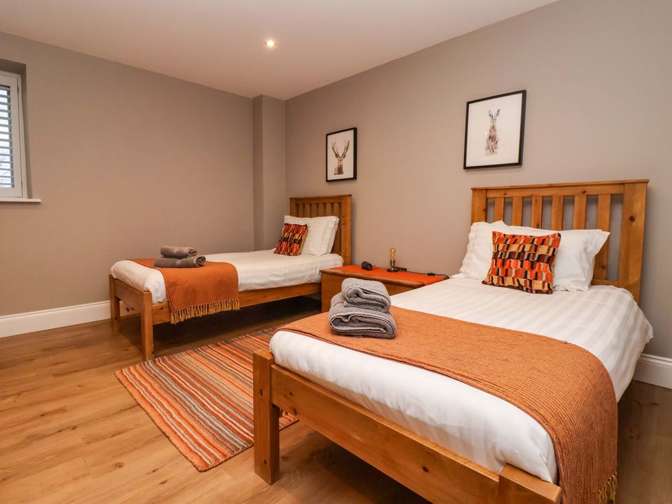 A bedroom with two beds and decorative wall art at The Cart House in Wilberfoss