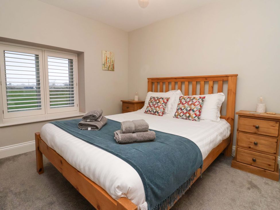 A bedroom with a bed and bedside tables at The Cart House in Wilberfoss