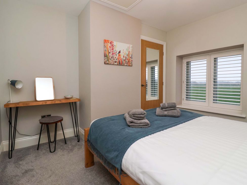 A bedroom with a bed and a table at The Cart House in Wilberfoss