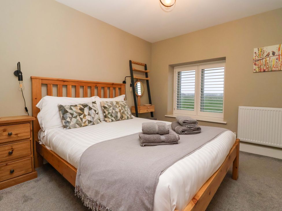 A bedroom with a bed and pillows at The Cart House in Wilberfoss